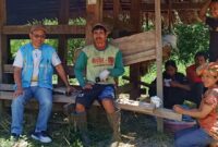 Manajer ULP PLN Rantepao, Sadcrak (kiri) Lukas Tandiara (tengah) Kristina Tandiallo (kanan) dan 3 orang dari tim PLN (belakang) saat berteduh di kandang kerbau, Sabtu 5 Oktober 2024 siang. Foto Dok: Ist.