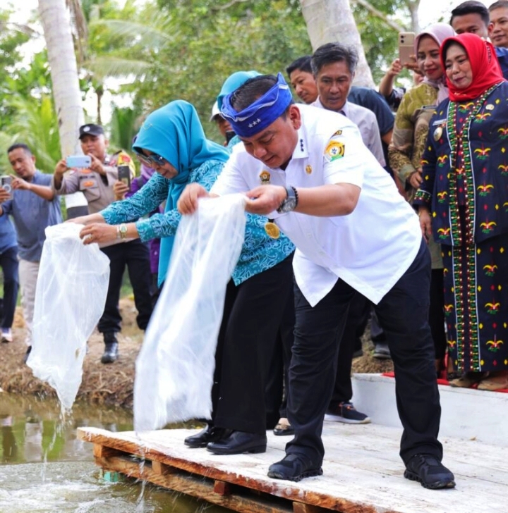 Kadis Ketahanan Pangan Pemprov Sultra saat ini Pjs Bupati Koltim, Ari Sismanto (kanan) saat menabur bibit ikan. Foto (Istimewa).