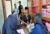 Ketua Bawaslu Briken Linde Bonting duduk dibelakang saat mengantar tersangka SP ke Kejari Tana Toraja (Jumat/15/11/2024) kemarin. Nampak SP duduk di kursi depan memakai kopia hitam di Ruangan Kejaksaan Tana Toraja. Foto Dok: Handover.