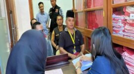 Ketua Bawaslu Briken Linde Bonting duduk dibelakang saat mengantar tersangka SP ke Kejari Tana Toraja (Jumat/15/11/2024) kemarin. Nampak SP duduk di kursi depan memakai kopia hitam di Ruangan Kejaksaan Tana Toraja. Foto Dok: Handover.