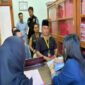 Ketua Bawaslu Briken Linde Bonting duduk dibelakang saat mengantar tersangka SP ke Kejari Tana Toraja (Jumat/15/11/2024) kemarin. Nampak SP duduk di kursi depan memakai kopia hitam di Ruangan Kejaksaan Tana Toraja. Foto Dok: Handover.