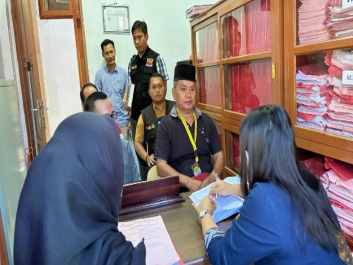 Ketua Bawaslu Briken Linde Bonting duduk dibelakang saat mengantar tersangka SP ke Kejari Tana Toraja (Jumat/15/11/2024) kemarin. Nampak SP duduk di kursi depan memakai kopia hitam di Ruangan Kejaksaan Tana Toraja. Foto Dok: Handover.