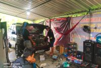 Driver Travel Lintas Sulawesi Aldo (kiri) dan Owners Garasi Dadakan, Broo Even langsung turun tangan lakukan pemasangan lampu variasi (costum lampu), di KM 8, Lembang Kepe' Tinoring, Kecamatan Mengkendek, Kabupaten Toraja Utara, Sulawesi Selatan, Sabtu (5/01/2024) sore. Foto Dok: Redaksi/inspirasipos.com.