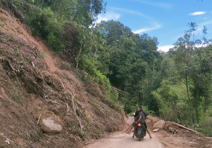 Material longsor yang menutup sebagian jalan di Lembang Rante, Jumat (18/04/2025) sore. Nampak pengendara sepeda motor berhati hati melewati jalan tersebut. Foto Dok: Moh Fadhli Wahab/inspirasipos.com.