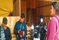Rasid (kiri), warga yang ditagih koperasi saat duduk pasrah didatangi dua karyawan koperasi di rumahnya. (ist)