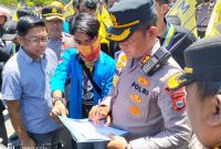 Salah satu perwakilan aksi dari Pergerakan Mahasiswa Islam Indonesia (PMII) Cabang Barru, memperlihatkan isi tuntutan mereka di hadapan Kapolres Barru, AKBP Ananda Fauzi Harahap, pada Selasa (2/09/2025). Foto Dok:(Kontributor/Erwanuddin).
